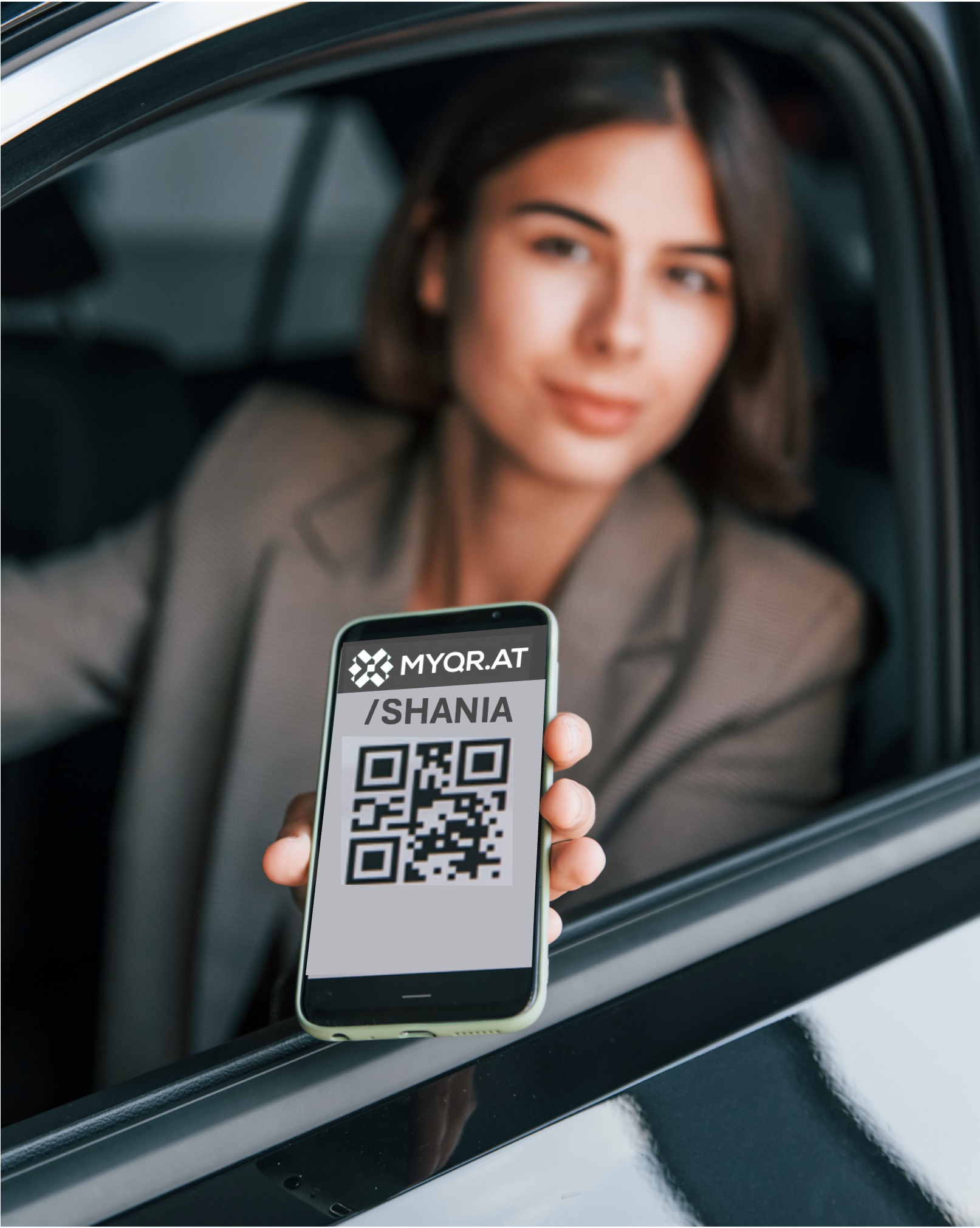 Shania holds up her phone from a car window, showing her MYQR code.